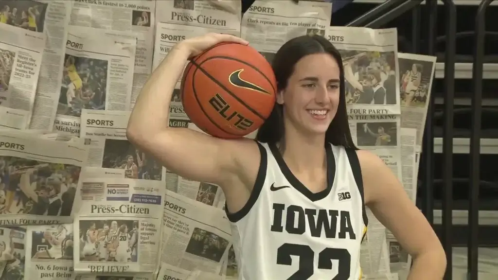Caitlin Clark holding a basketball on her shoulder